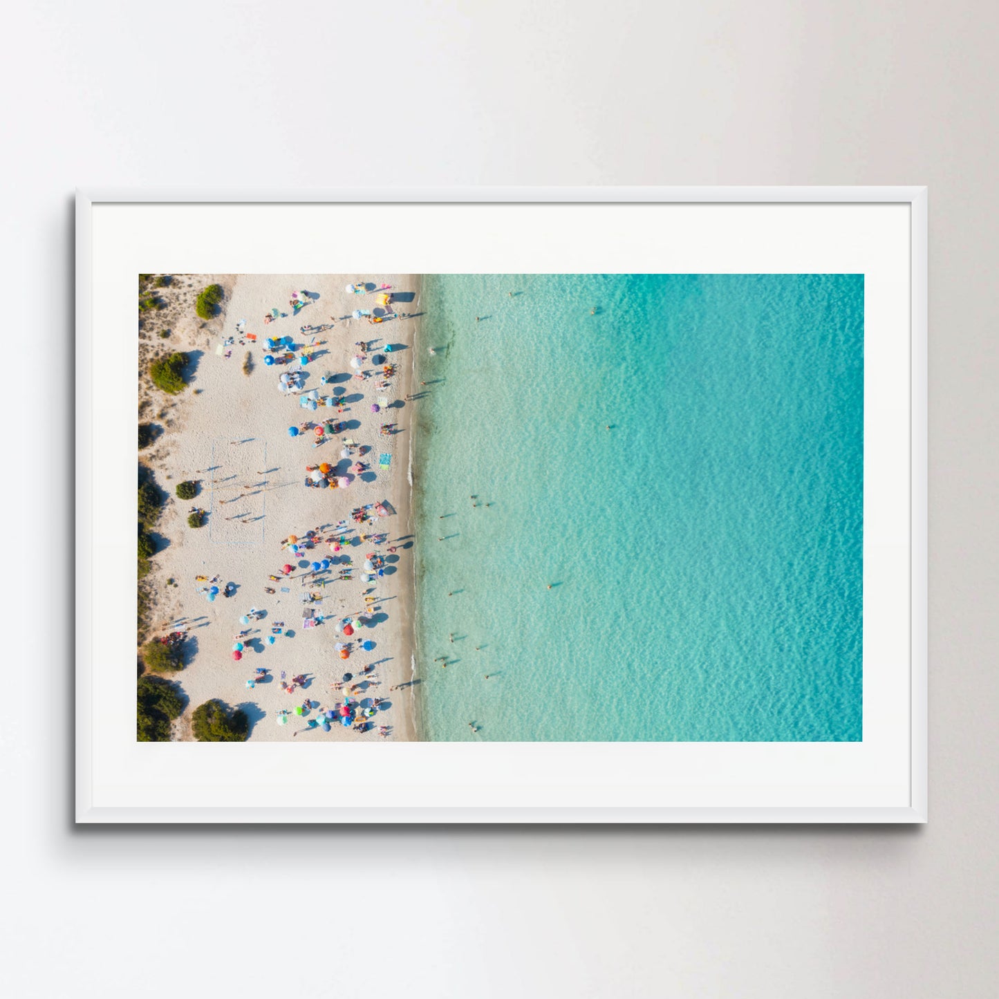 View from above, stunning aerial view of a white sand beach full of beach umbrellas and people swimming in a turquoise water. Spiaggia del Principe, Costa Smeralda, Sardinia, Italy.