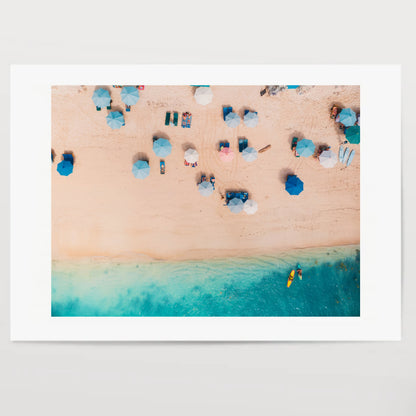 Top view of sandy beach with turquoise sea water and colorful blue umbrellas, aerial drone shot