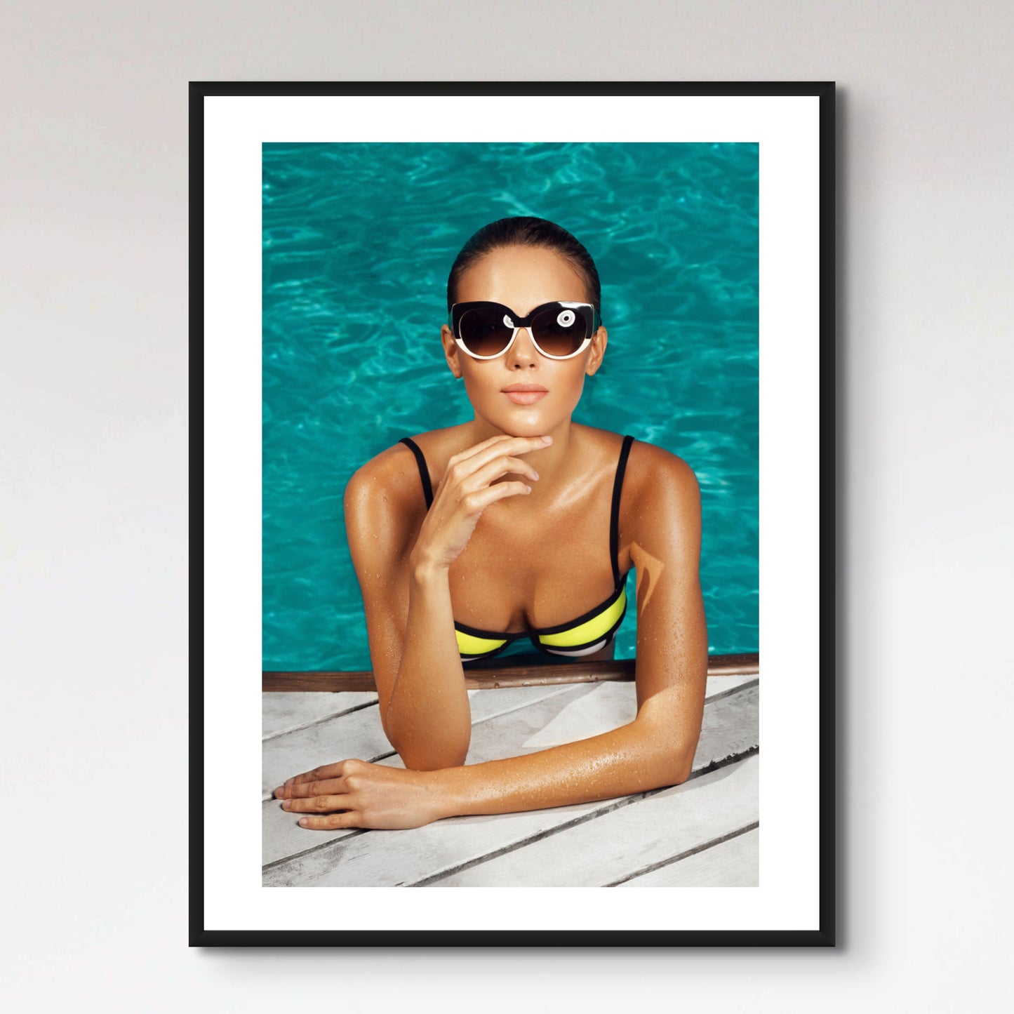 woman near the pool, wearing glasses and swimsuit, tans