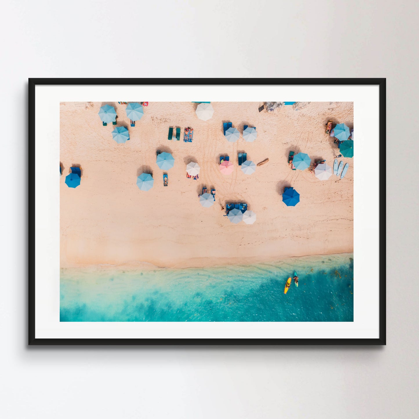 Top view of sandy beach with turquoise sea water and colorful blue umbrellas, aerial drone shot