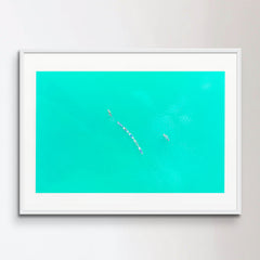 SUP surfing. Aerial image of people paddling on sup boards and turquoise water.