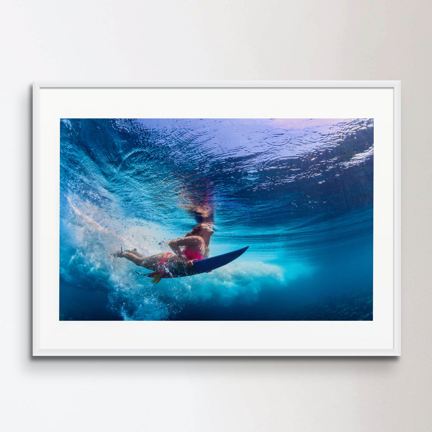 Beautiful surfer girl diving under water with surf board