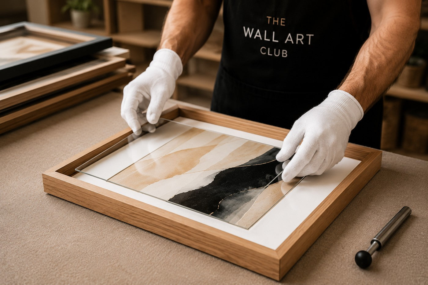 A framed artwork being carefully assembled by hand