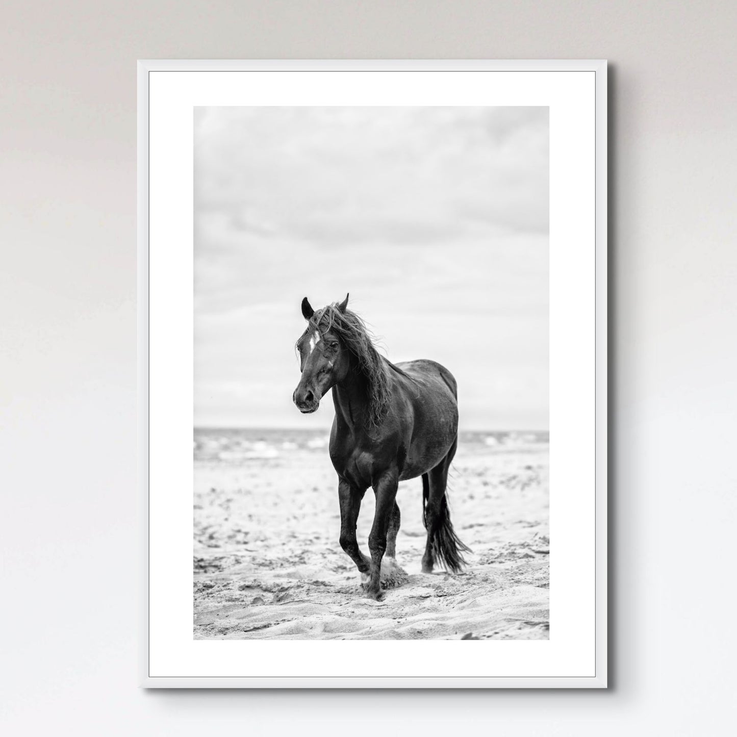 Brown horse walking by the sea on the sandy beach.