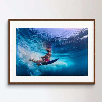 Beautiful surfer girl diving under water with surf board